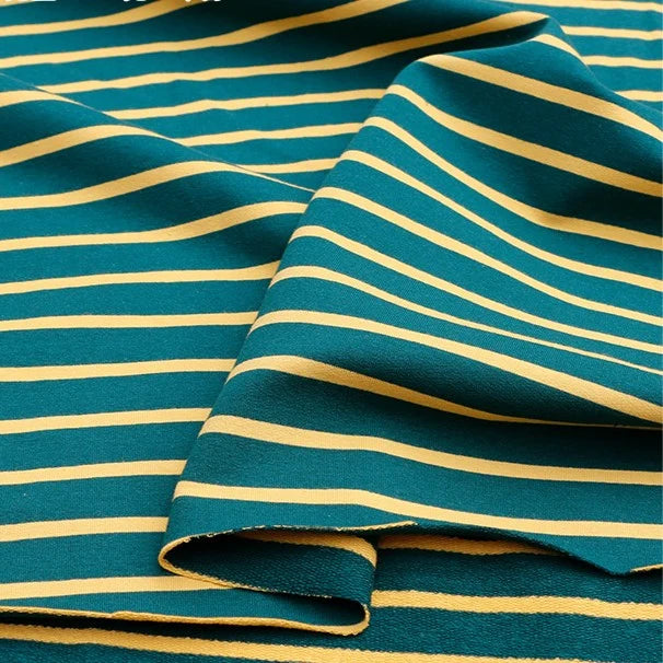 A close-up of Longan Craft’s Colorful Striped Stretch French Terry Fabric shows horizontal teal and yellow stripes on soft knit cotton-spandex, perfect by the yard for cozy sweatshirts.