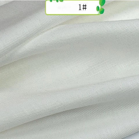 A close-up of smooth, white Longan Craft Colorful Twill 100 Lyocell Fabric shows fine diagonal texture and subtle sheen; the top features a partial green label with "1#" on it.