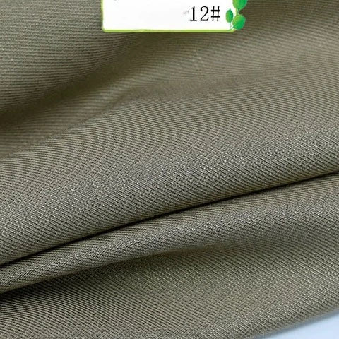 Close-up of Longan Craft's Colorful Twill 100 Lyocell Fabric by the yard, featuring fine diagonal weave and khaki color. A white label marked "12#" appears in the upper right corner. Sustainable and comfortable material for suits.