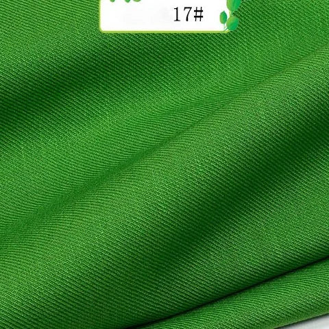 Bright green Colorful Twill 100 Lyocell Fabric by Longan Craft, featuring a subtle diagonal weave and sustainable material, is shown in soft folds. A label at the top displays 17#. Ideal textile for suits.