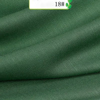 Close-up of Colorful Twill 100 Lyocell Fabric By The Yard from Longan Craft, showing green ribbed texture and soft folds; a white label with "18#" and two green leaf graphics highlights this sustainable material for suits.
