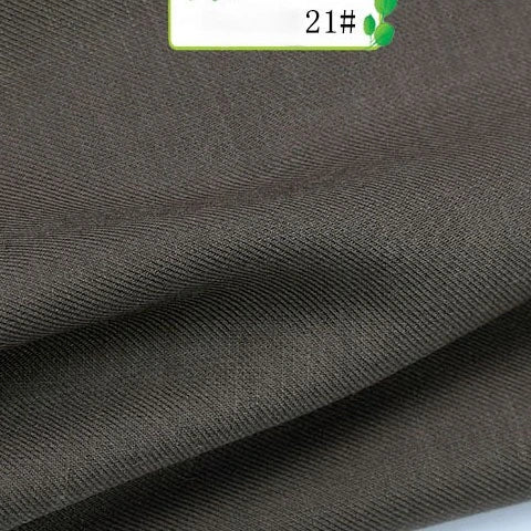A close-up of Colorful Twill 100 Lyocell Fabric By The Yard from Longan Craft shows its dark brown, finely woven texture, neatly folded with a partially visible label marked 21#. This sustainable lyocell material is perfect for suits.