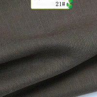 A close-up of Colorful Twill 100 Lyocell Fabric By The Yard from Longan Craft shows its dark brown, finely woven texture, neatly folded with a partially visible label marked 21#. This sustainable lyocell material is perfect for suits.