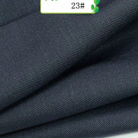 Close-up of folded dark navy blue Longan Craft Colorful Twill 100 Lyocell Fabric By The Yard shows its fine texture. A small label with green accents and the number 23# is visible at the top, highlighting this sustainable textile for suits.