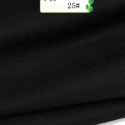 Close-up of Longan Craft’s Colorful Twill 100 Lyocell Fabric, a smooth black textile with fine diagonal lines. A small green and white “25#” label appears at the edge, highlighting this sustainable fabric for suits.