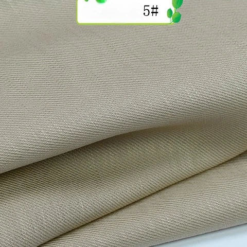 Close-up of Longan Craft’s Colorful Twill 100 Lyocell Fabric by the Yard, in light beige with a subtle diagonal weave, neatly folded and showing part of a 5# label—sustainable and ideal for suits.