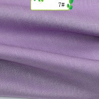 A close-up shows folded Colorful Twill 100 Lyocell Fabric by the yard from Longan Craft, featuring textured lavender material with a soft sheen and a partially visible label marked 7# and green leaves, highlighting its sustainable comfort.