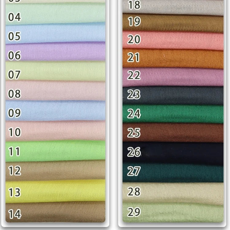 Stacked rows of Longan Craft's Colorful Viscose Challis Fabric By The Yard, labeled 04–29, show an array of lighter to darker hues. This lightweight, breathable polyester viscose is ideal for sun protection shirts and creative sewing projects.