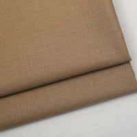 A folded piece of Colorful Worsted Wool Fabric By The Yard in a solid tan, tightly woven texture.