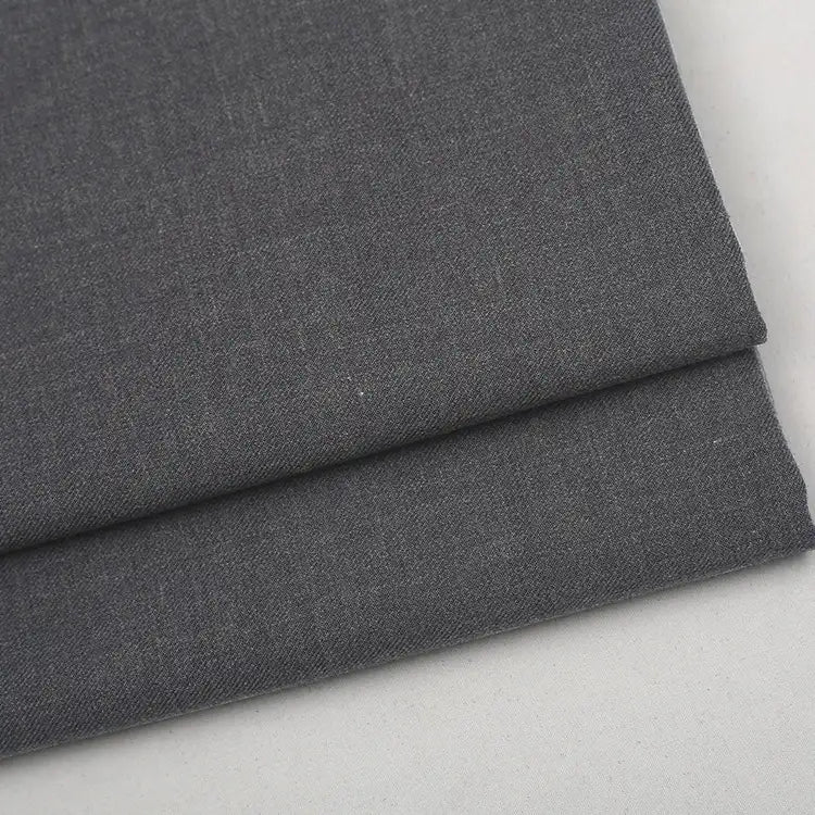 Folded piece of premium dark gray Colorful Worsted Wool Fabric By The Yard in a woven wool polyester blend.