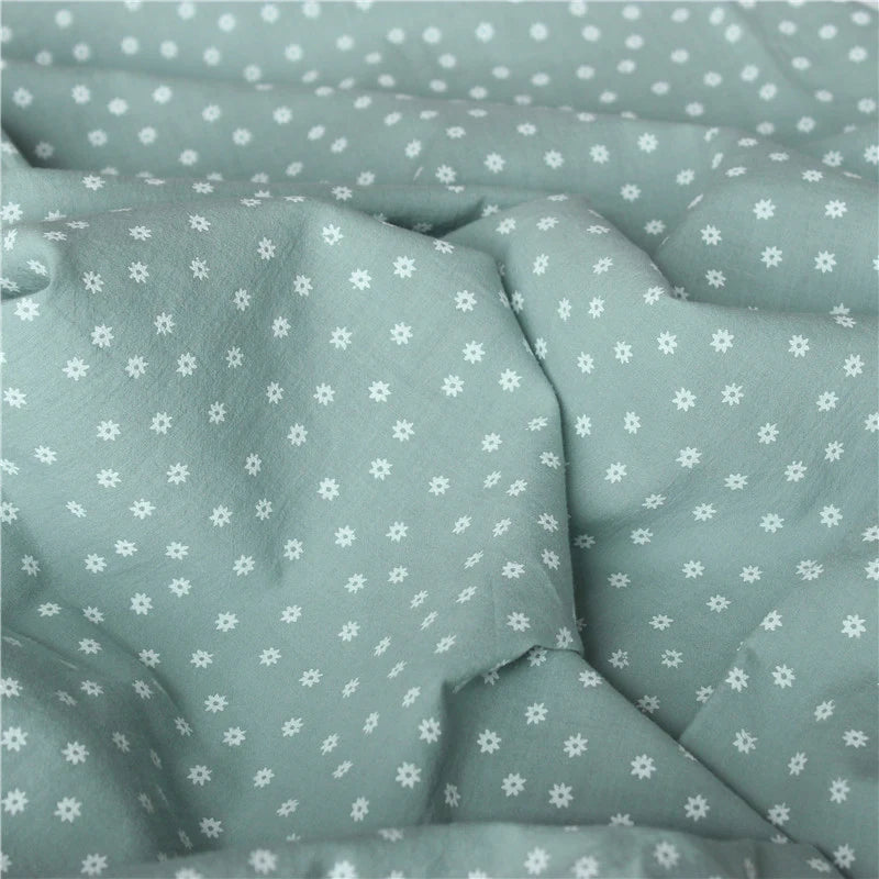 Close-up of Cotton Floral Printed Voile Fabric By The Yard from Longan Craft, featuring a light green floral design with white flowers and polka dots. This multicolor washed cotton voile is soft, breathable, and perfect for casual wear.