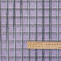 Here’s the revised sentence using your product data: The Longan Craft Cotton Gingham Sueded Flannel Fabric By The Yard features a multicolor plaid pattern with thin black and green stripes on a soft, comfy sueded flannel material. A wooden ruler marked in centimeters is placed horizontally at the bottom for scale.