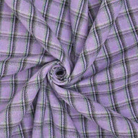 A close-up of Longan Craft’s Cotton Gingham Sueded Flannel Fabric by the yard, featuring a multicolor polyester checked pattern in black, white, green, and purple, arranged in a spiral display.