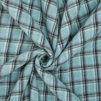 The Cotton Gingham Sueded Flannel Fabric by Longan Craft features a light blue, black, and white plaid pattern, shown gathered in the center in a spiral to highlight its soft texture and cozy folds.