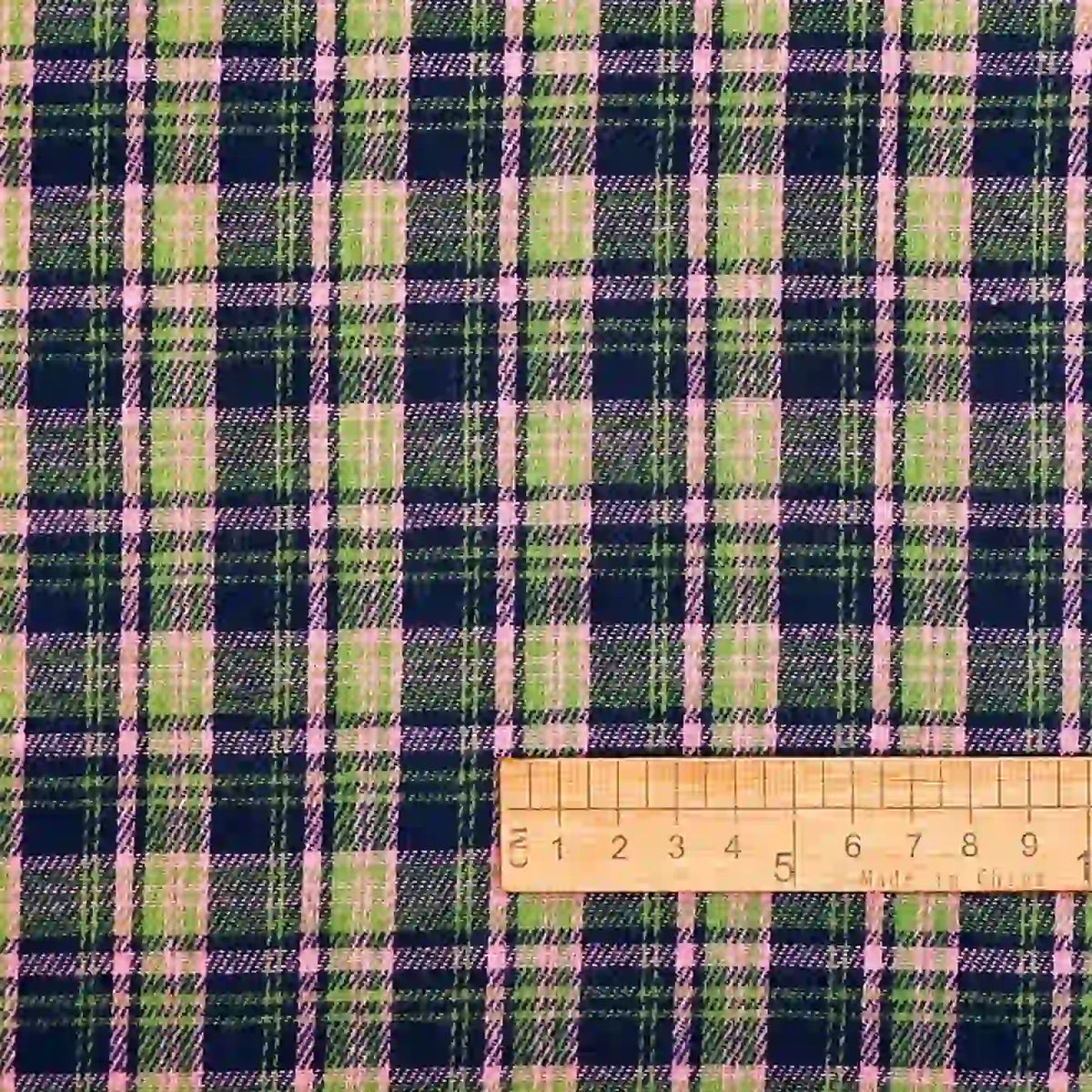 A close-up of Longan Craft’s Cotton Gingham Sueded Flannel Fabric by the yard, featuring a multicolor plaid pattern in green, navy, and pink tones; a wooden ruler showing centimeters is placed at the bottom right for scale.