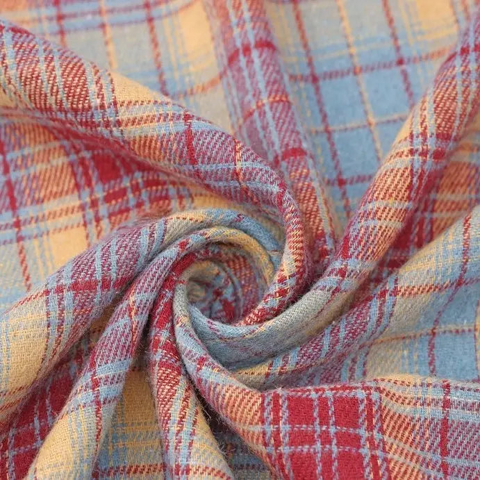 A close-up of Longan Craft’s Cotton Jacquard Plaid Flannel Fabric by the yard features cozy, one-sided brushed checked material in red, yellow, and blue tones twisted into a spiral, highlighting its intersecting plaid lines and textured jacquard weave—a perfect autumn flannel fabric for clothing.