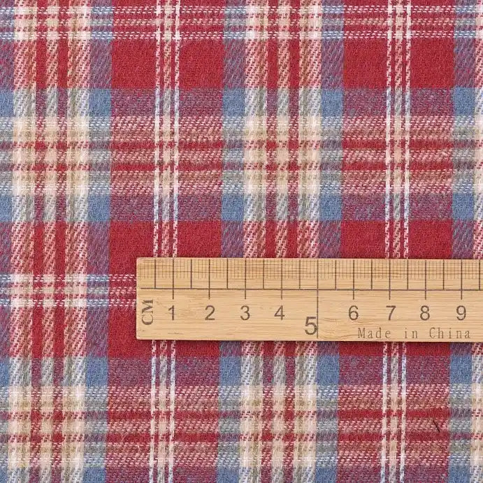 A wooden ruler marked “Made in China” measures the width, in centimeters, of Longan Craft’s Cotton Jacquard Plaid Flannel Fabric By The Yard, shown here in a red, blue, and white checked pattern.