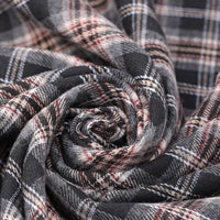Close-up of Longan Craft’s Cotton Jacquard Plaid Flannel Fabric By The Yard, a one-sided brushed checked flannel material in black, gray, and red hues, artfully swirled to highlight its cozy autumn texture and woven jacquard detail.