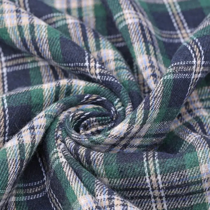 Close-up of Longan Craft Cotton Jacquard Plaid Flannel Fabric by the yard, twisted to display the detailed texture and weave of its blue, green, and white checked, one-sided brushed flannel—perfect for cozy autumn clothing projects.