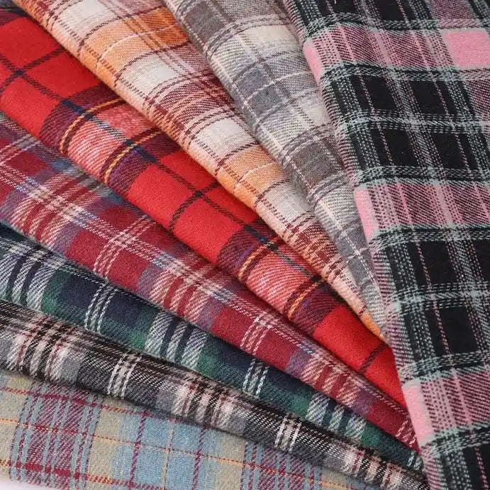 Multiple pieces of Longan Craft Cotton Jacquard Plaid Flannel Fabric By The Yard, featuring a variety of colors such as red, blue, pink, orange, and gray, are layered diagonally and displayed in a fanned arrangement. These cozy autumn one-sided brushed checked flannel fabrics are perfect for clothing projects.