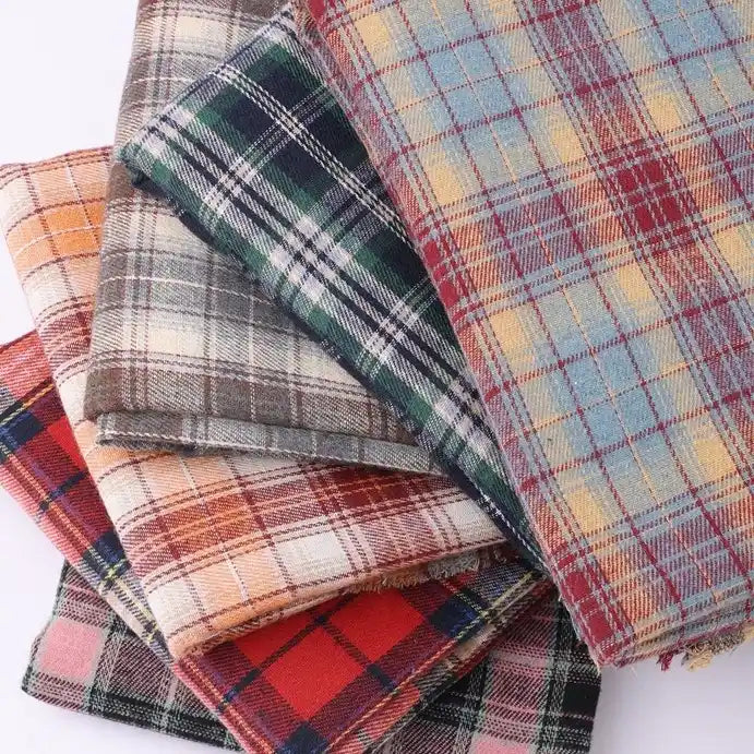 Five pieces of Longan Craft Cotton Jacquard Plaid Flannel Fabric by the yard, featuring a one-sided brushed checked design in assorted colors and patterns, are stacked together to highlight their soft texture and cozy appearance—perfect for autumn clothing projects.