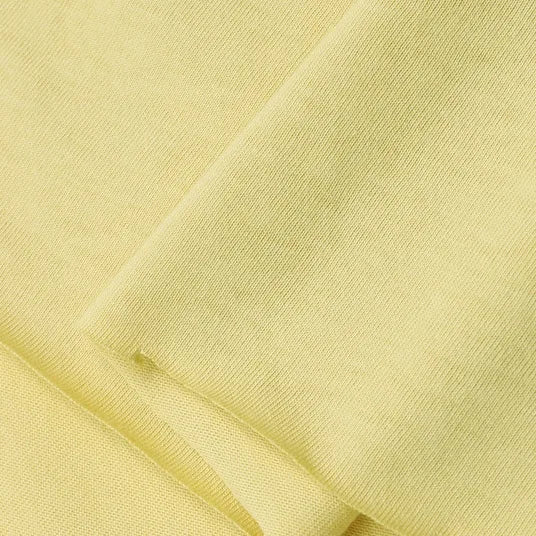 A close-up of Longan Craft’s Cotton Jersey Fabric By The Yard shows its soft, light yellow surface, fine texture, and subtle folds—ideal breathable material for making casual wear.