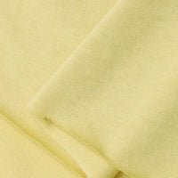 A close-up of Longan Craft’s Cotton Jersey Fabric By The Yard shows its soft, light yellow surface, fine texture, and subtle folds—ideal breathable material for making casual wear.