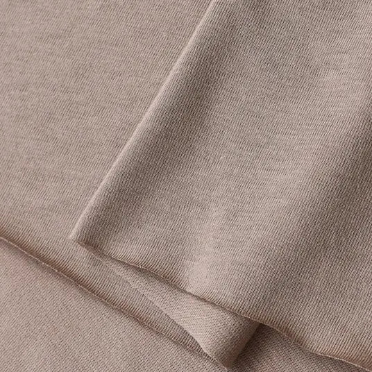 A close-up of Longan Craft’s Cotton Jersey Fabric By The Yard, showing its light brown, soft, smooth texture and fine knit—perfect colorful single jersey material for casual wear.