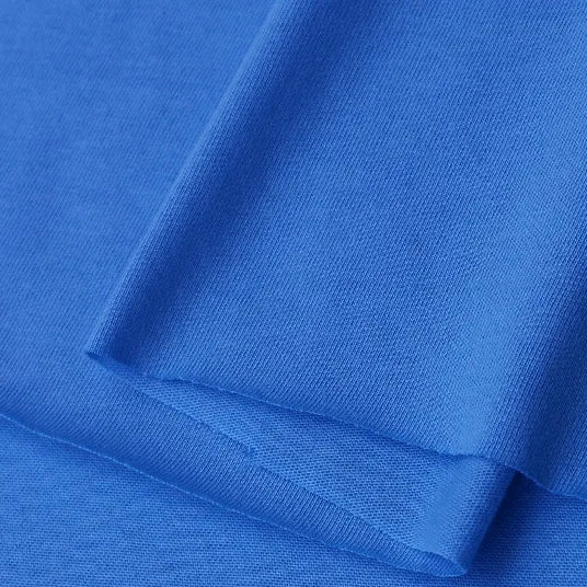 A close-up of Longan Craft's Cotton Jersey Fabric By The Yard reveals its smooth texture and fine weave. This soft, lightweight, and breathable solid blue single jersey material is perfect for making casual wear.