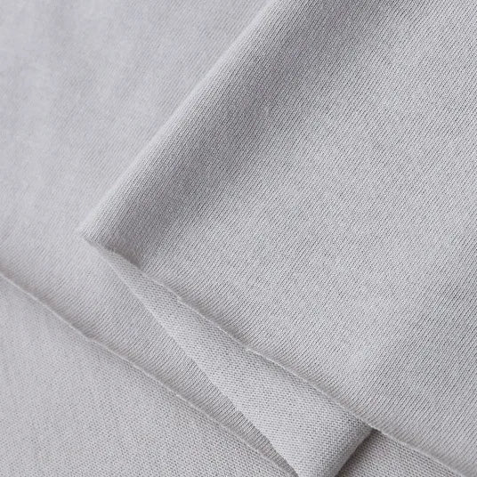 A close-up of Longan Craft's Cotton Jersey Fabric By The Yard, showcasing its light gray color, soft 100% cotton feel, smooth texture, and fine weave—perfect for casual wear and DIY projects.