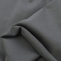 Close-up of Longan Craft Cotton Jersey Fabric By The Yard reveals its smooth, slightly textured surface in dark gray. This colorful, breathable single jersey material is soft and ideal for comfortable casual wear.