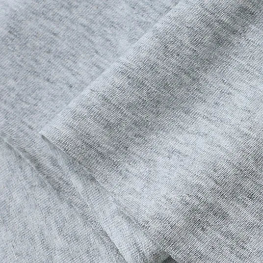 A close-up of Longan Craft's Cotton Jersey Fabric By The Yard showcases its soft, breathable texture and subtle color variations, ideal for casual wear. This colorful single jersey material appears smooth and lightweight with visible folded edges.