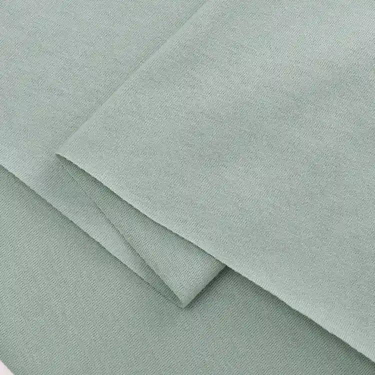 Folded pieces of Longan Craft Cotton Jersey Fabric By The Yard in light green are layered, displaying a soft, textured surface and clean edges—ideal colorful single jersey material for making casual wear.