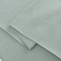 Folded pieces of Longan Craft Cotton Jersey Fabric By The Yard in light green are layered, displaying a soft, textured surface and clean edges—ideal colorful single jersey material for making casual wear.