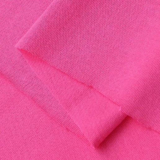 Close-up of Longan Craft's Cotton Jersey Fabric By The Yard in bright pink, folded to highlight its fine weave, soft texture, and breathable quality—ideal single jersey material for making casual wear.