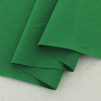 Two pieces of Longan Craft Cotton Jersey Fabric By The Yard, a colorful and soft single jersey ideal for casual wear, are partially overlapped on a light, speckled background.