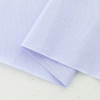 A close-up of Longan Craft's Cotton Jersey Fabric By The Yard, neatly folded on a white surface, highlights its smooth, soft texture and breathable quality—ideal colorful single jersey material for making casual wear.