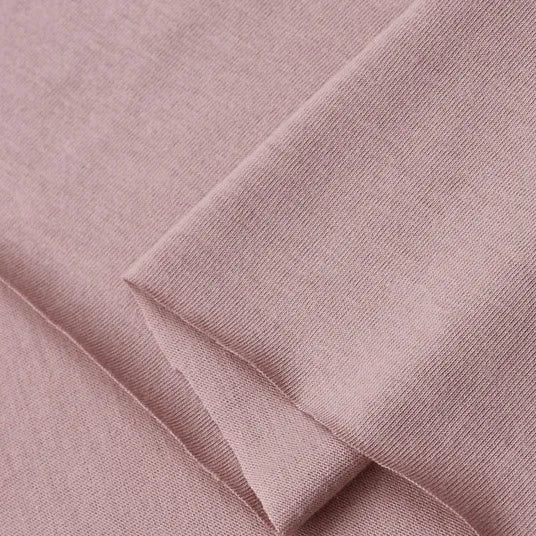 A close-up of Longan Craft's Cotton Jersey Fabric By The Yard in light mauve-pink, showing its soft, breathable single jersey texture—ideal for making casual wear.