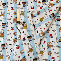 Cute Dog Print Striped Canvas Fabric By The Yard featuring a pattern of cartoon bears, puppies, and hearts on a light blue and white striped background, shown with a metal ruler for scale.