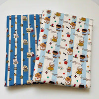 Two folded pieces of Longan Craft Cute Dog Print Striped Canvas Fabric By The Yard: one with blue and white stripes featuring bear illustrations and the other with a white background featuring various puppies, party hats, and text.