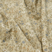 Close-up of Longan Craft’s Daisy Print 16 Wale Corduroy Fabric By The Yard, a soft, fine wale 100% cotton corduroy material in beige featuring a delicate floral pattern of small white, blue, and brown flowers with green stems—perfect for fall DIY projects.