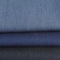Three folded pieces of Longan Craft Denim Color Twill Viscose Fabric in light, medium, and dark blue—chic stretch elastane material by the yard, perfect for stylish tailored trousers and dressmaking.