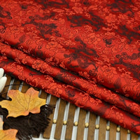Longan Craft’s Dragon Pattern Brocade Fabric by the Yard features intricate multicolor chinoiserie dragon and floral motifs, shown neatly folded on a bamboo mat with autumn leaves and dark brown tassels for decoration.