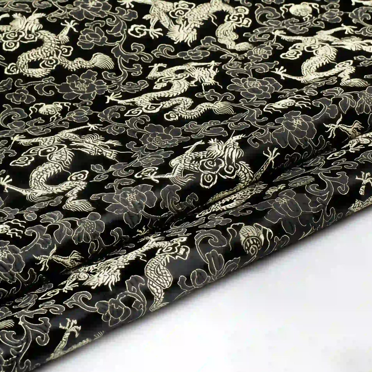 Longan Craft’s Dragon Pattern Brocade Fabric by the yard features intricate multicolor chinoiserie dragon, cloud, and floral motifs. This vintage brocade cloth material exudes an ornate East Asian style, with rich details visible along its slightly folded edge.