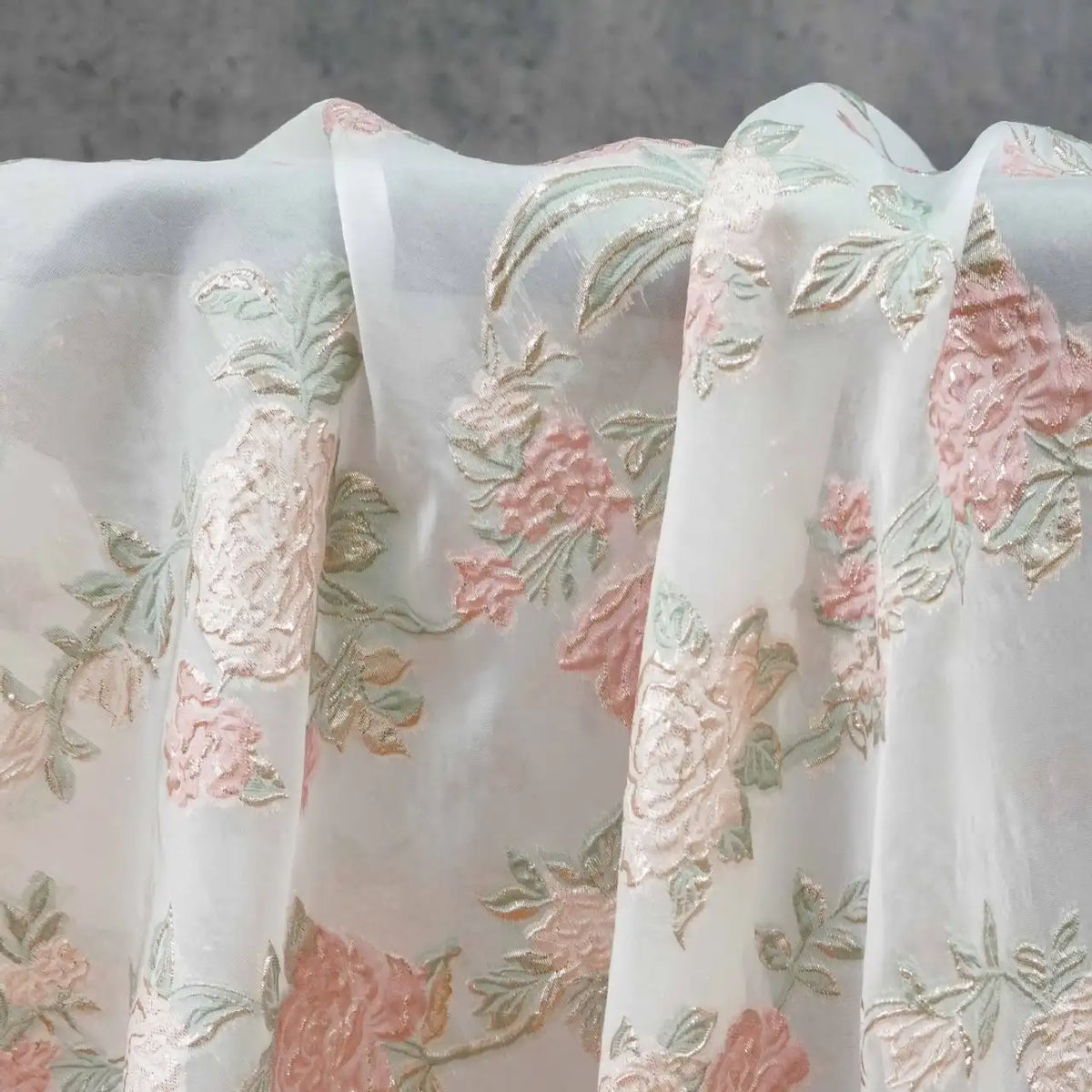 Longan Craft's Embossed Rose Organza Fabric features sheer, gold floral jacquard and drapes softly in delicate folds—perfect for camisole tops and elegant decor.
