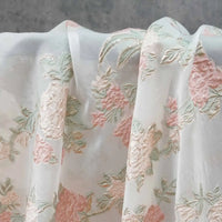 Longan Craft's Embossed Rose Organza Fabric features sheer, gold floral jacquard and drapes softly in delicate folds—perfect for camisole tops and elegant decor.