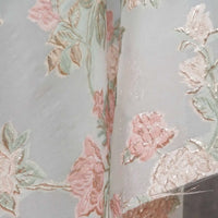 Close-up of Longan Craft’s Embossed Rose Organza Fabric—a sheer, lightweight fabric with gold floral jacquard pattern on a silvery background. Ideal for camisole tops, it has a subtle sheen that highlights the delicate rose design.