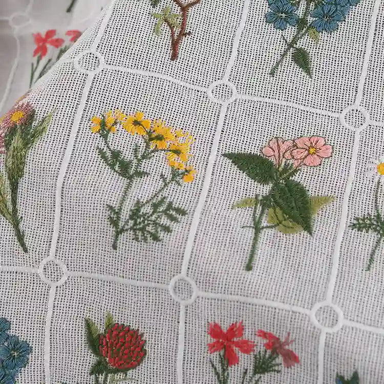 Close-up of Longon Craft’s Plant Floral Embroidered Cotton Fabric by the yard—a soft grid cotton material featuring colorful embroidered flowers in each square, ideal for apparel.