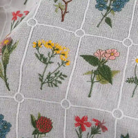 Close-up of Longon Craft’s Plant Floral Embroidered Cotton Fabric by the yard—a soft grid cotton material featuring colorful embroidered flowers in each square, ideal for apparel.