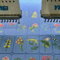 A close-up of Longon Craft’s Plant Floral Embroidered Cotton Fabric By The Yard shows colorful botanical embroidery in a neat grid on breathable, soft cotton—ideal for apparel and creative projects.